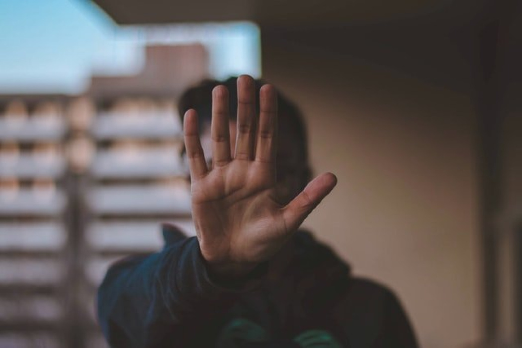 Person holding up hand in a stop gesture, symbolizing the importance of understanding workers' compensation rights and claims process.